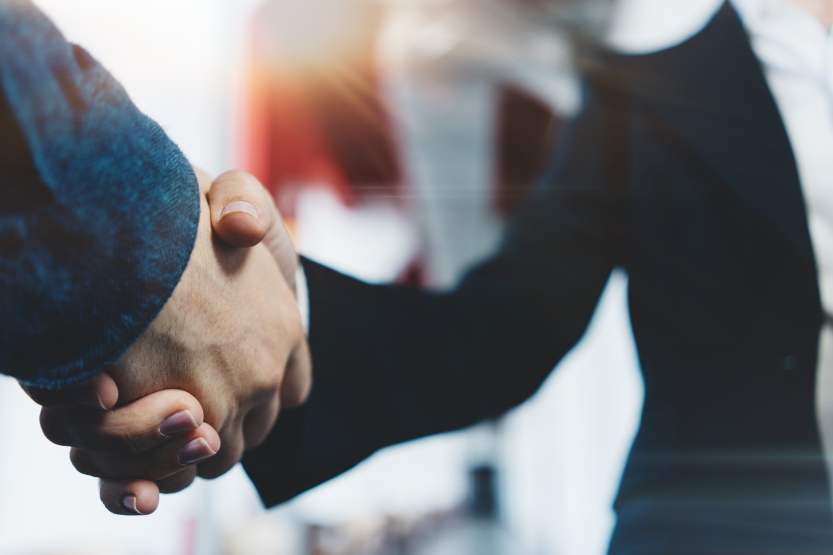 Business people shake hands in office after successful deal and partnership